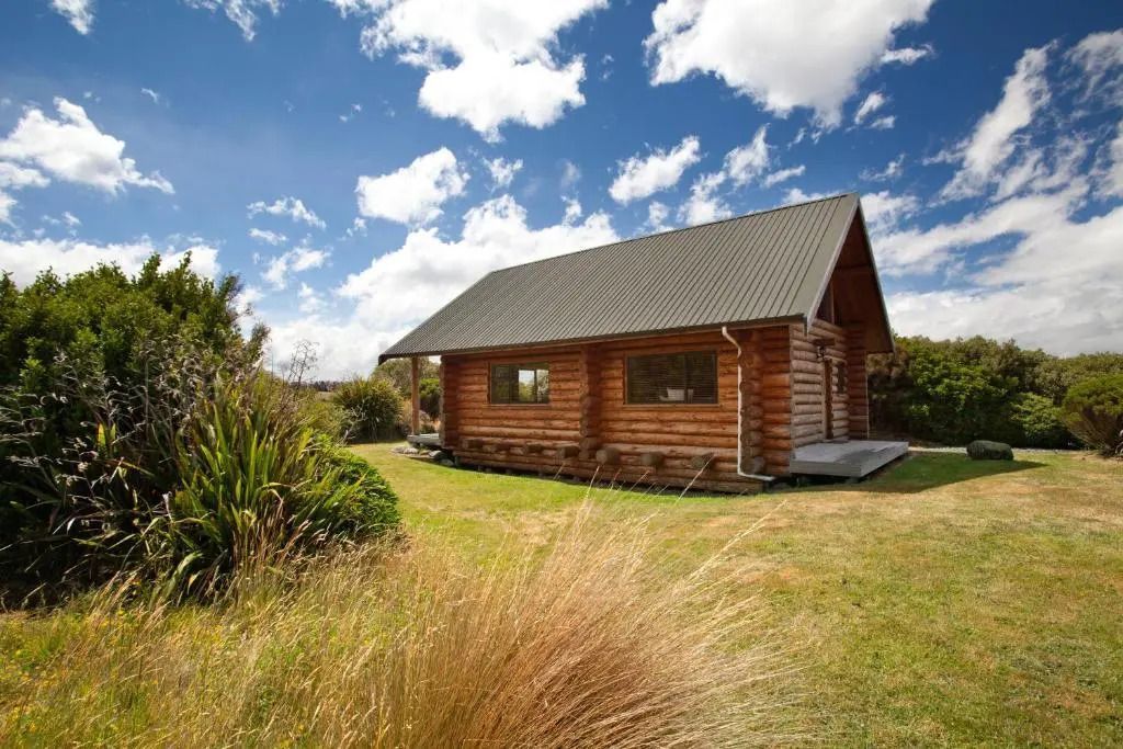 Gemütliche Holzhütte im Grünen unter blauem Himmel
