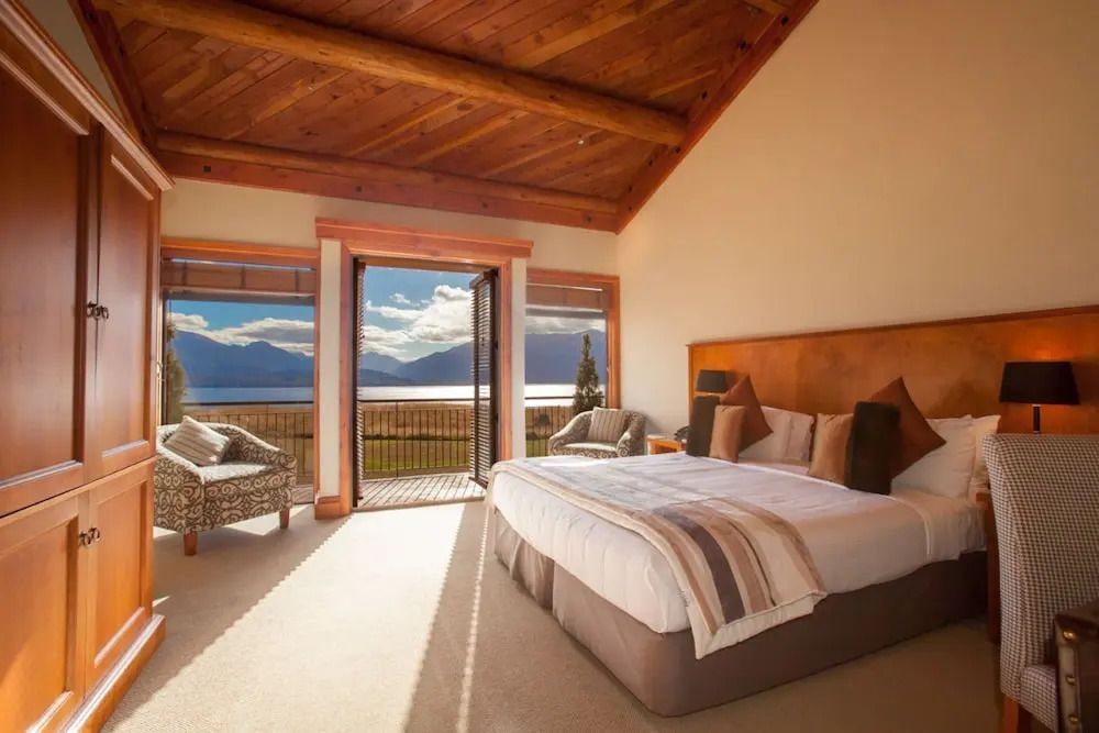 Helles Deluxe Zimmer mit großem Bett und Aussicht auf die Landschaft