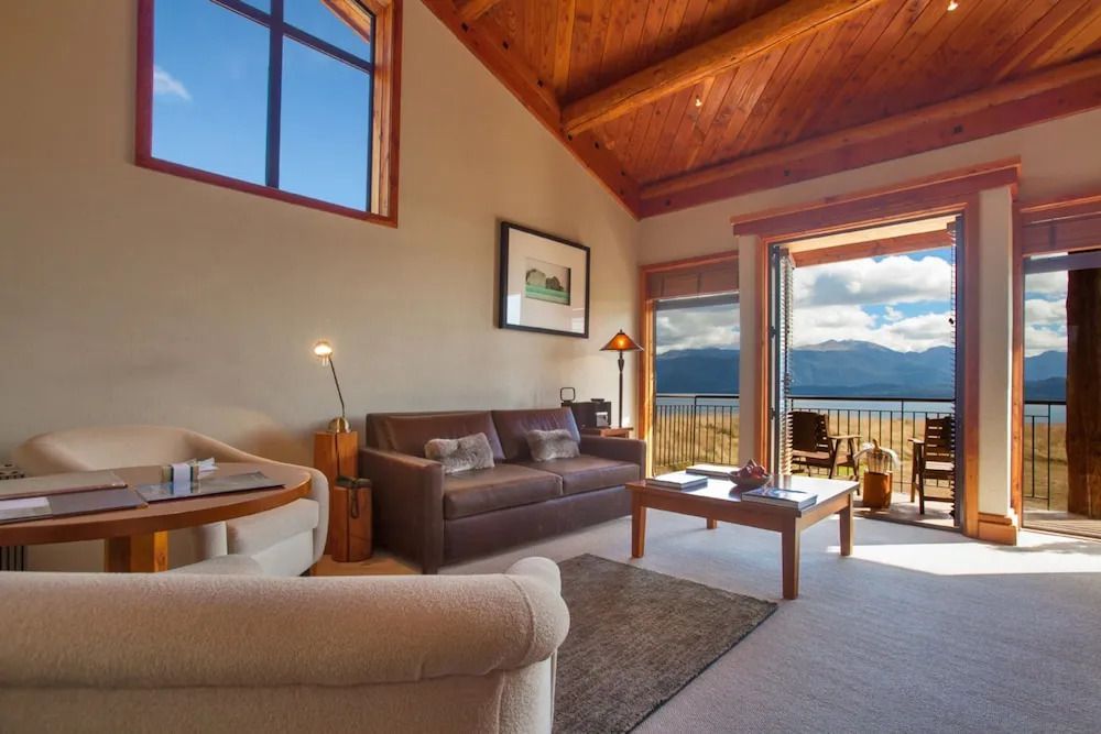 Wohnzimmer der Executive Suite mit Sofas, großem Fenster und Balkonblick.