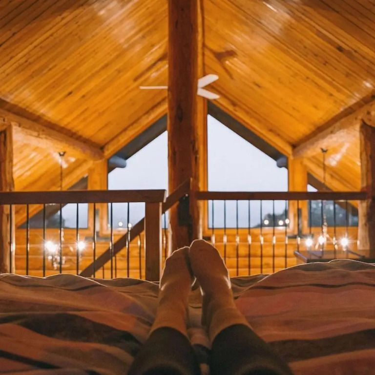 Gemütliche Zimmeransicht mit Blick auf verglaste Holzwände und Landschaft.
