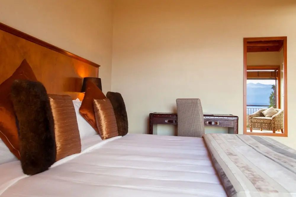 Schlafzimmer mit elegant dekoriertem Bett und Schreibtisch im Standard Zimmer.