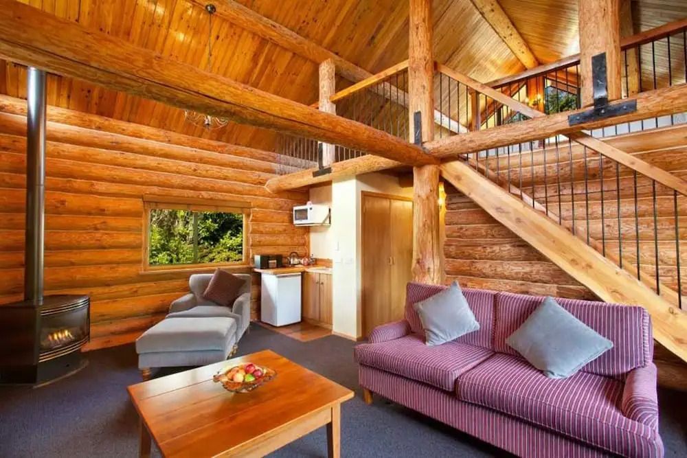 Gemütliches Wohnzimmer in einer Blockhütte mit Sofa und rustikalem Holzdekor