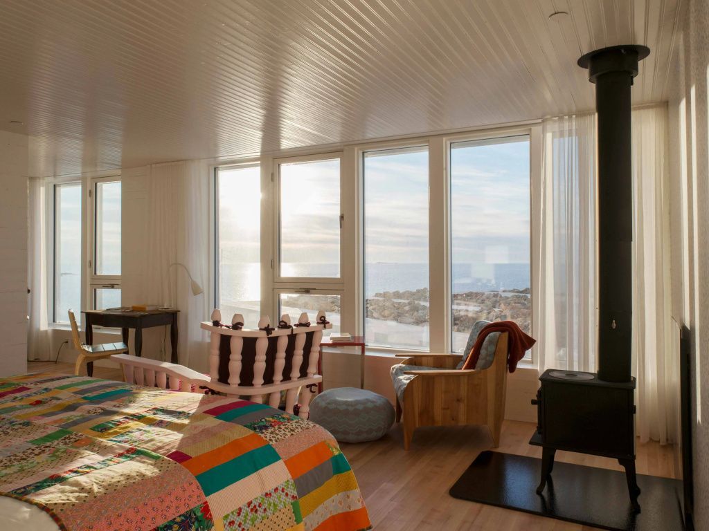 Helles Schlafzimmer mit buntem Patchwork-Bett und Meerblick