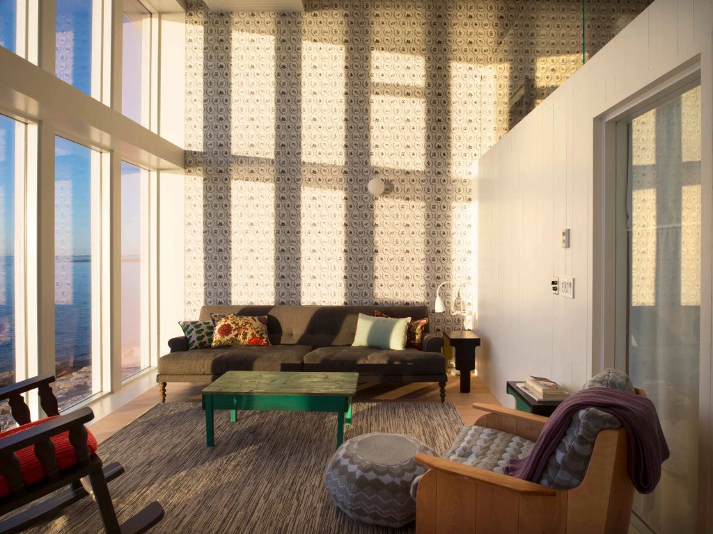 Wohnbereich mit gemütlichem Sofa und hoher Fensterfront