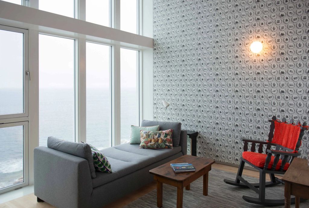Sitzecke mit Meerblick durch große Fenster in der Suite