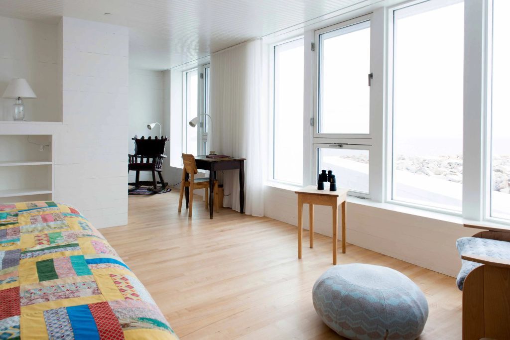 Helles Zimmer mit stilvollen Möbeln und Blick auf die Küste