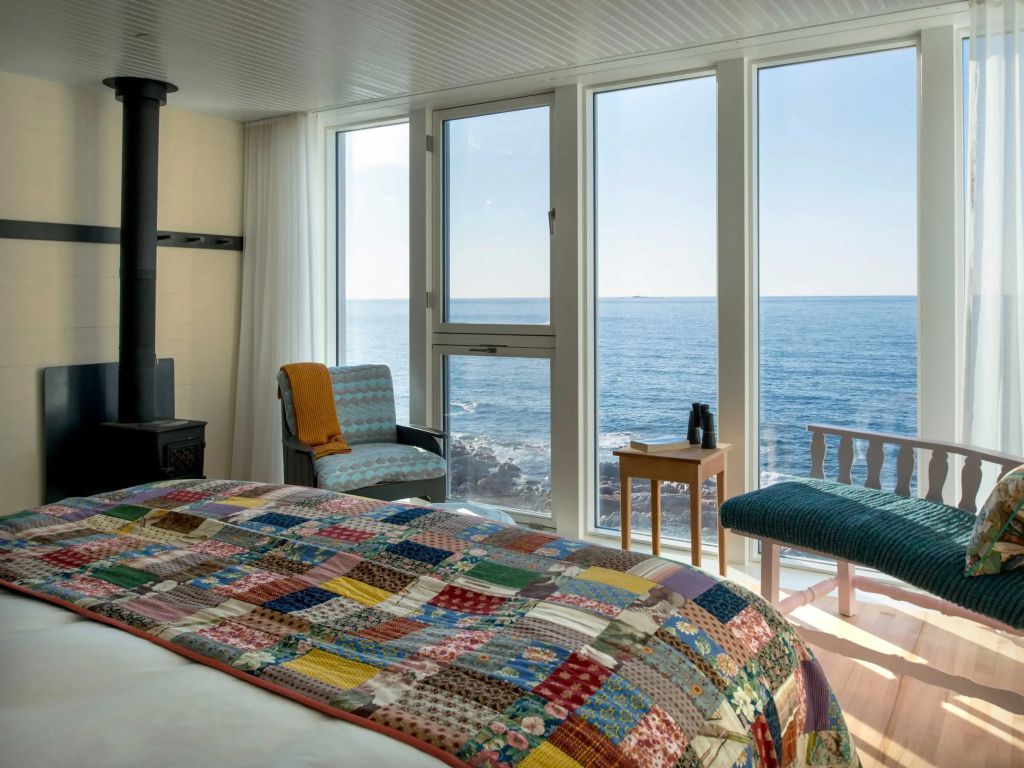 Gemütliches Schlafzimmer mit großen Fenstern und Blick auf den Atlantik