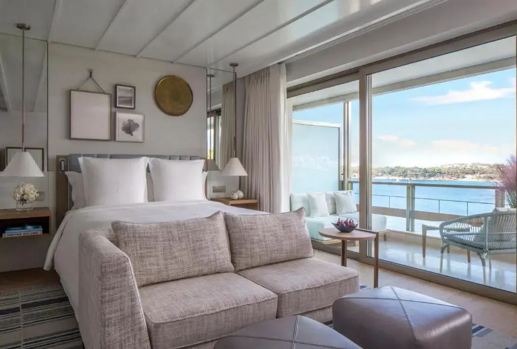 Modernes Arion Doppelzimmer mit großem Bett, Sofa und privatem Balkon zum Meer.