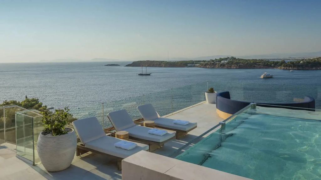 Private Terrasse mit Infinity Pool, Sonnenliegen und Panoramablick auf das Meer.