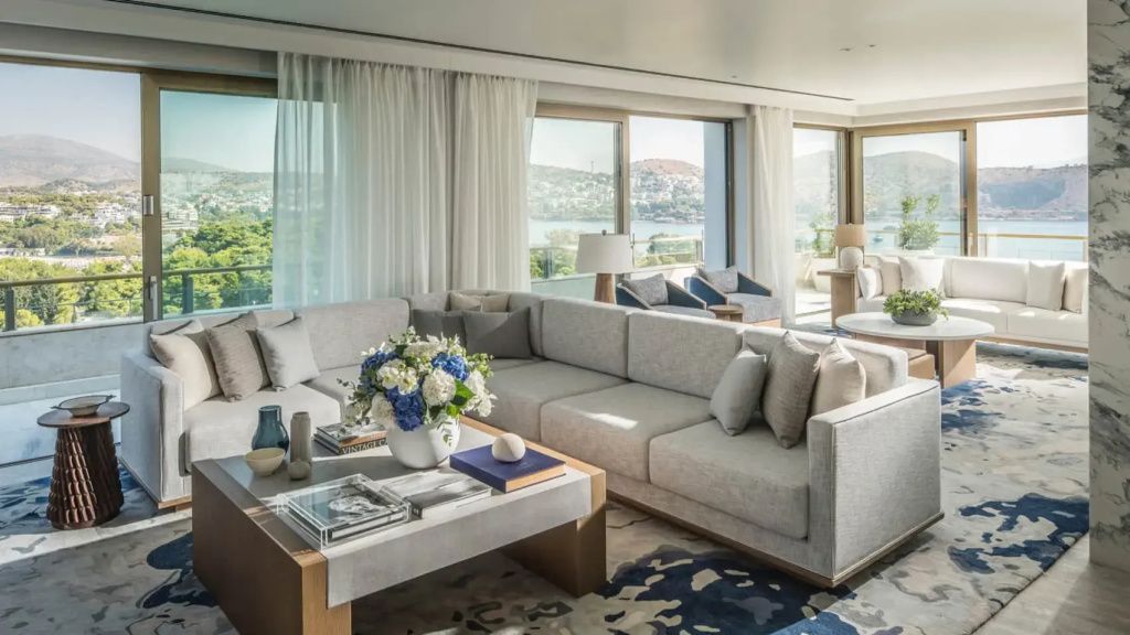 Großzügiger Wohnbereich der Suite mit eleganter Eckcouch und Panoramafenstern zum Meer.