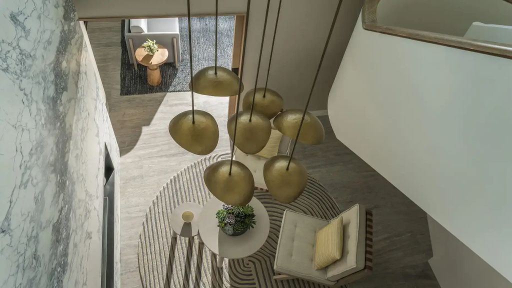 Moderne goldene Pendelleuchten über einer stilvollen Sitzecke in der Suite.