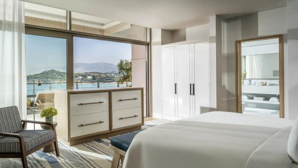 Schlafbereich der Arion Royal Vierer Suite mit weißem Kleiderschrank und Meerblick durch große Fensterfront.