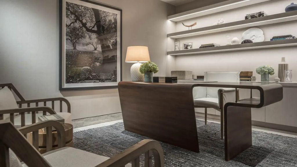 Elegantes Arbeitszimmer der Arion Royal Suite mit modernem Holztisch und beleuchtetem Wandregal.