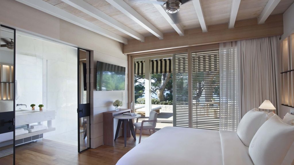 Moderne Inneneinrichtung des Bungalows mit Flachbild TV, Sitzbereich und Zugang zur Terrasse.