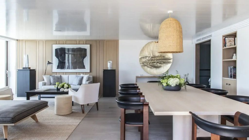 Großzügiger Essbereich in der Nafsika Ambassador Suite mit langem Holztisch und Designleuchte.