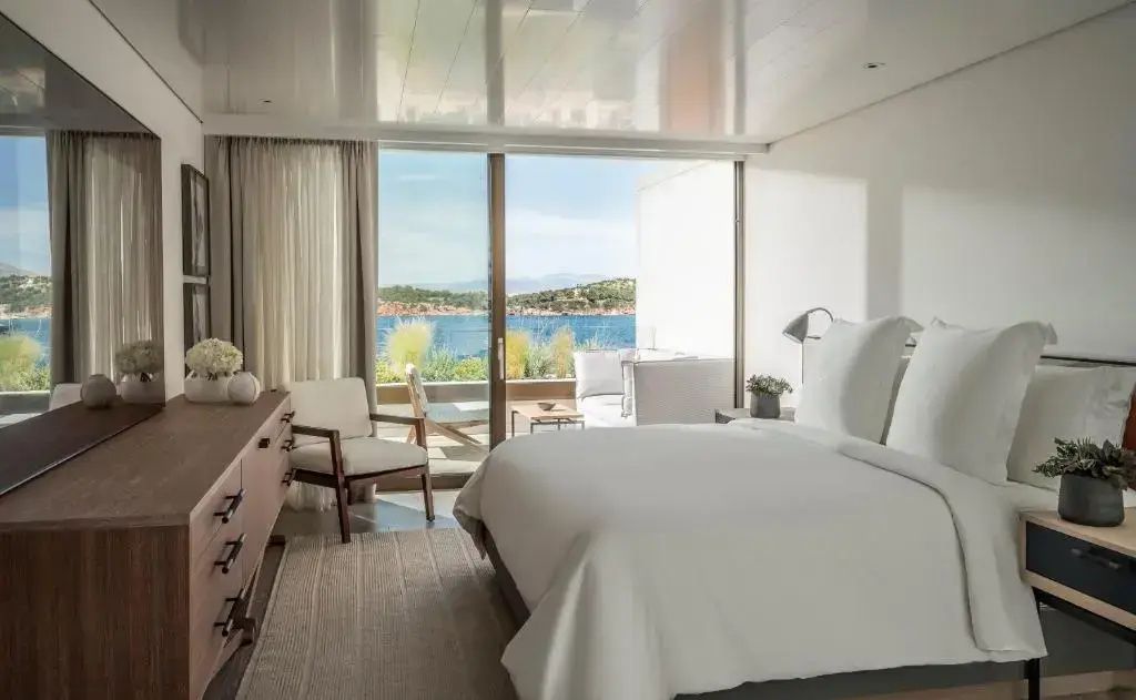 Schlafzimmer der Nafsika Suite mit großem Doppelbett und weitem Blick auf das Meer.