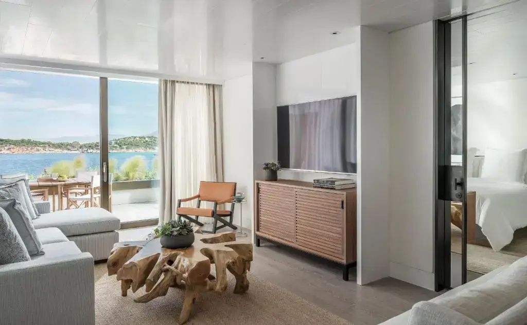 Wohnbereich der Suite mit elegantem Holz-Couchtisch, Flachbild-TV und Sessel.