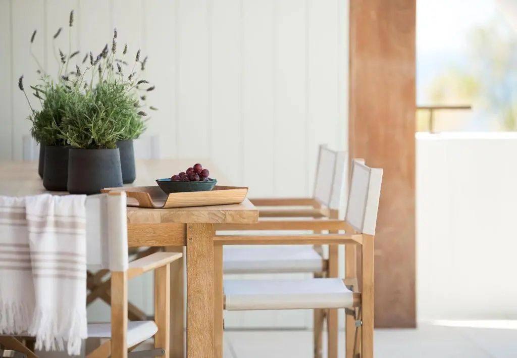 Sonniger Essbereich auf der privaten Terrasse mit eleganten Holzstühlen