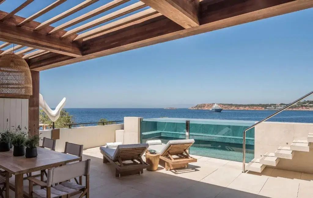 Sonnenterrasse der Suite mit privatem Pool, Liegestühlen und Panoramablick auf das Meer