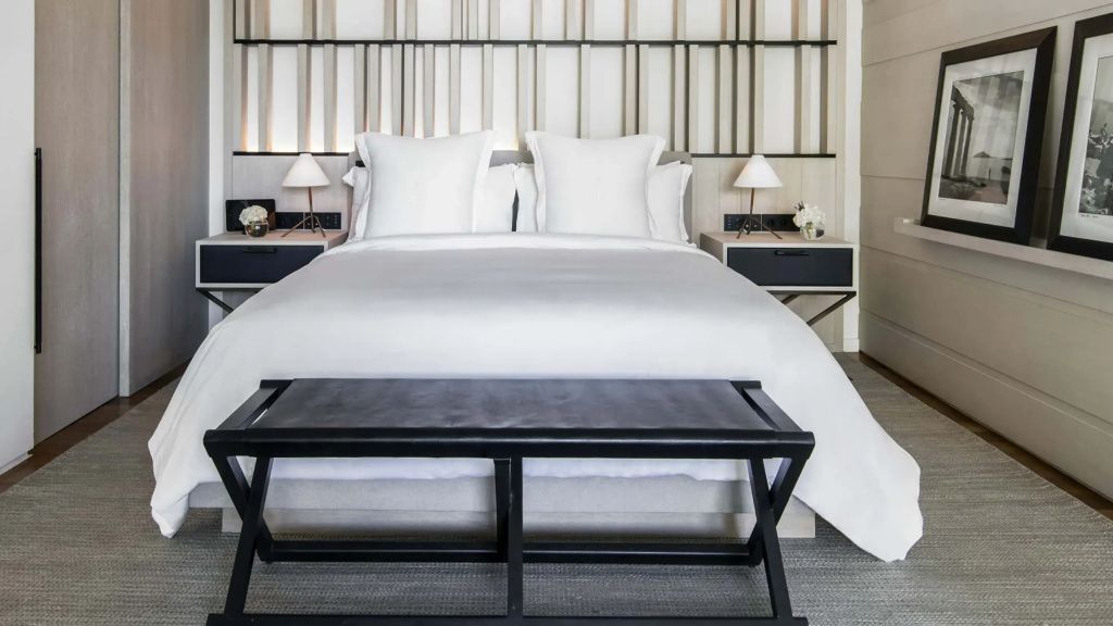 Luxuriöses Doppelbett der Pool Bungalow Suite mit stilvoller Wandverkleidung und eleganten Nachttischen.