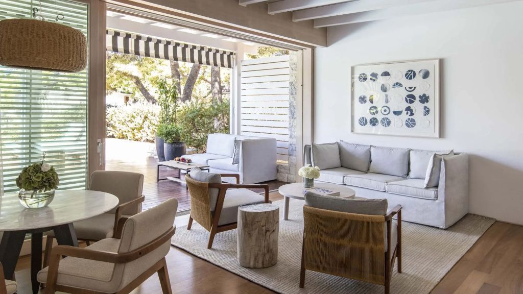 Großzügiger Wohnbereich der Bungalow Suite mit fließendem Übergang zur überdachten Terrasse.