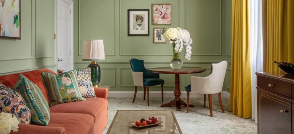 Elegante Sitzecke mit Tisch, Kunstwerken und Blumen in der Belvedere Suite