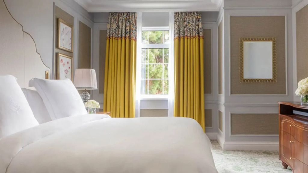 Elegantes Schlafzimmer mit gelben Vorhängen und großem Doppelbett
