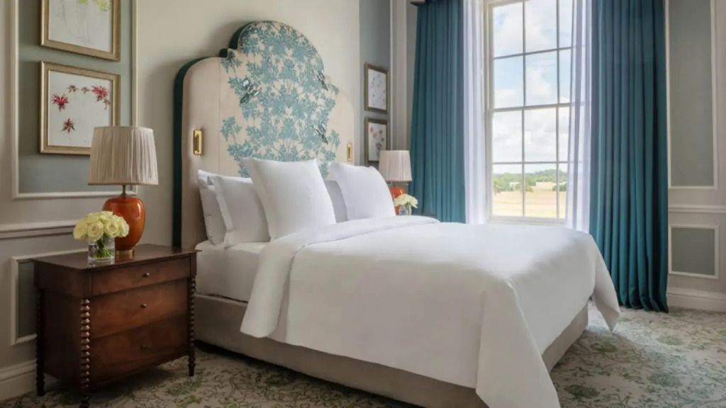 Elegant eingerichtetes Doppelzimmer mit großem Fenster und luxuriösem Bett.