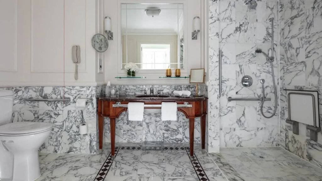 Luxuriöses Badezimmer mit Marmorfliesen und elegantem Waschtisch in der Suite.