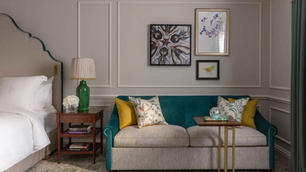Gemütliche Sitzecke im Garden Deluxe Zimmer mit Kunstwerken und stilvollen Möbeln.
