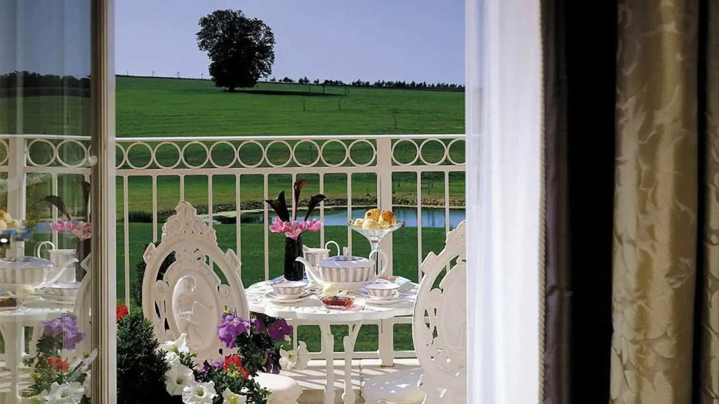 Private Terrasse mit Ausblick ins Grüne und eleganten Gartenmöbeln.