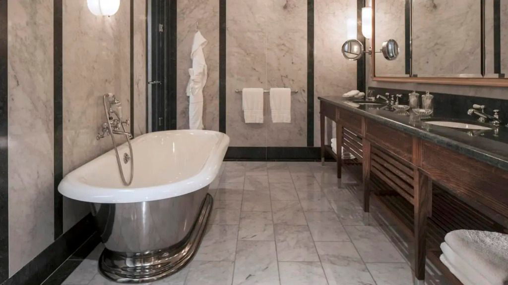 Luxuriöses Badezimmer mit freistehender Badewanne und edlen Marmorelementen.