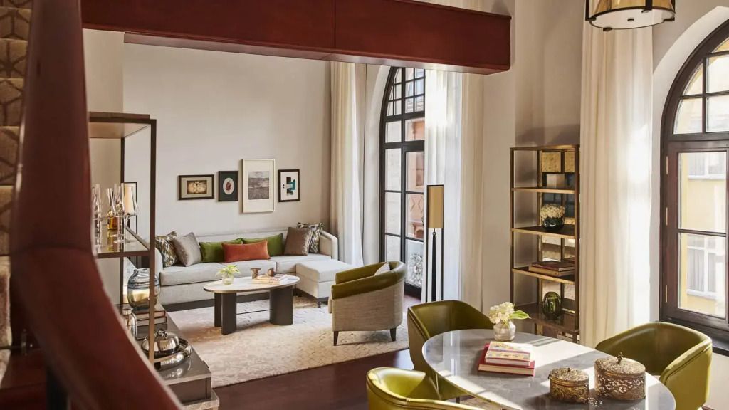 Offener Wohnbereich mit eleganten Sesseln und Bücherregal.