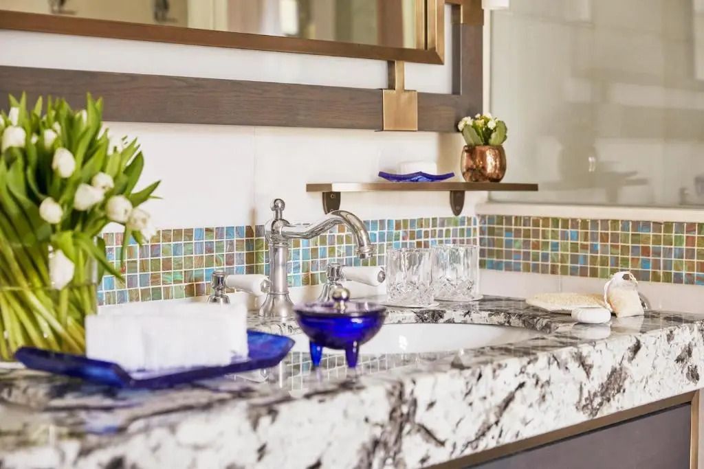 Luxuriöses Badezimmer mit Marmorwaschtisch und eleganter Armatur im Deluxe Zimmer.