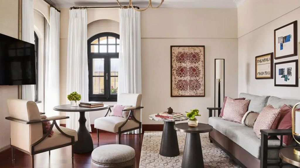 Erlesene Sitzecke mit Kunstwerk und großen Fenstern in Hotelzimmer