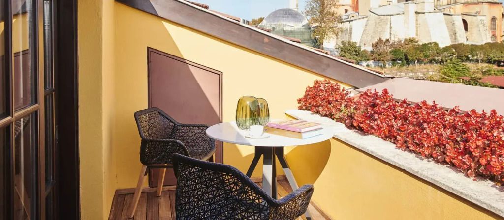 Kleiner Balkon mit gelber Wand und tollem Ausblick