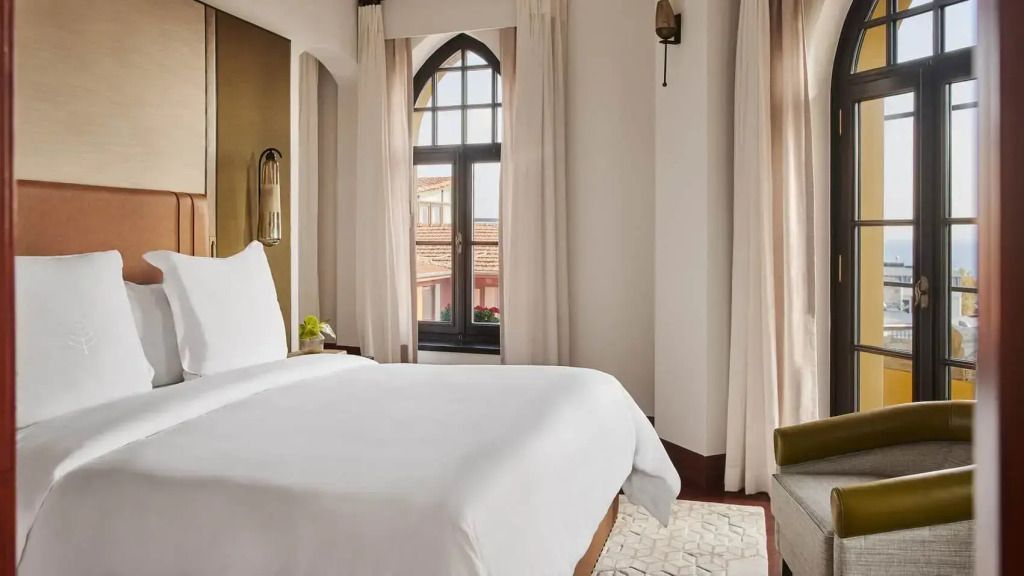 Helles Schlafzimmer mit Doppelbett in der Pasha Suite mit Blick auf historische Gebäude