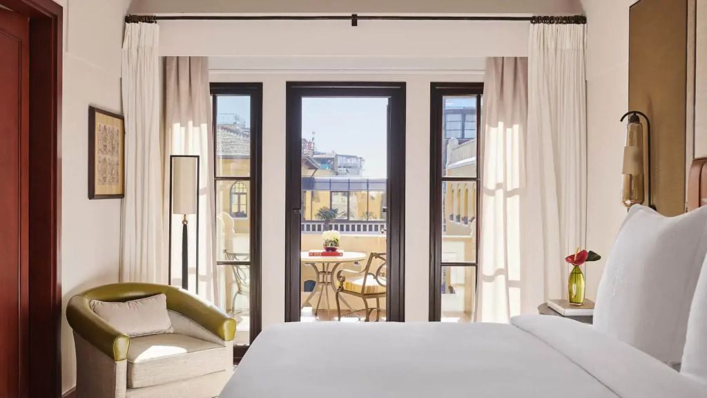 Helles Schlafzimmer mit Balkonblick und Sitzbereich