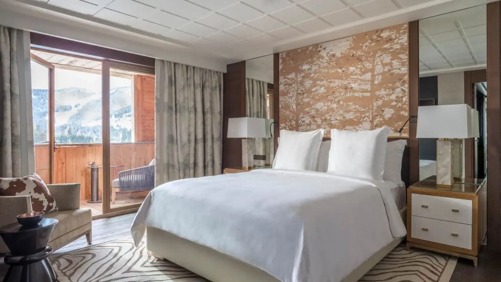Geräumiges Schlafzimmer mit Doppelbett, Holzverkleidung und großen Fenstern.