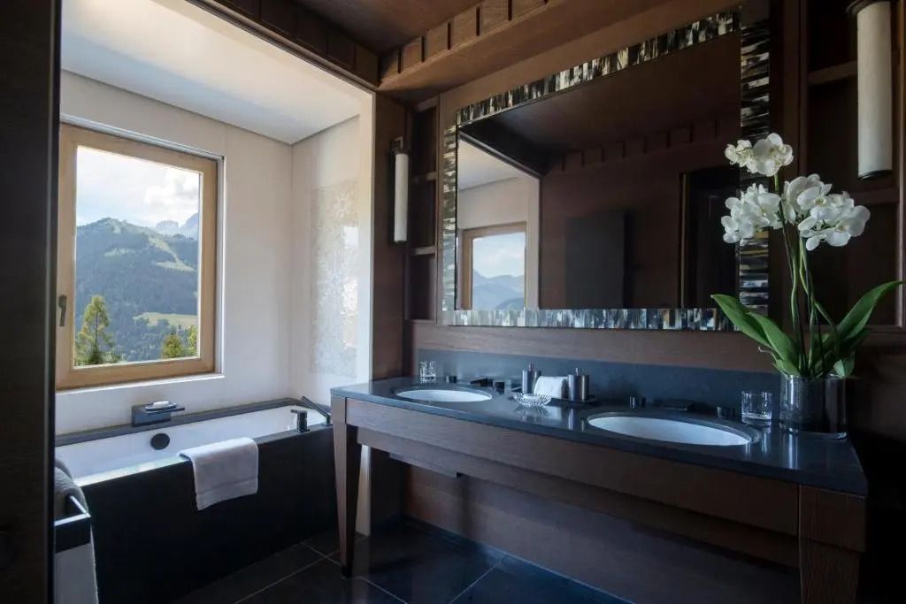 Modernes Badezimmer mit zwei Waschbecken und Blick auf die Berge.