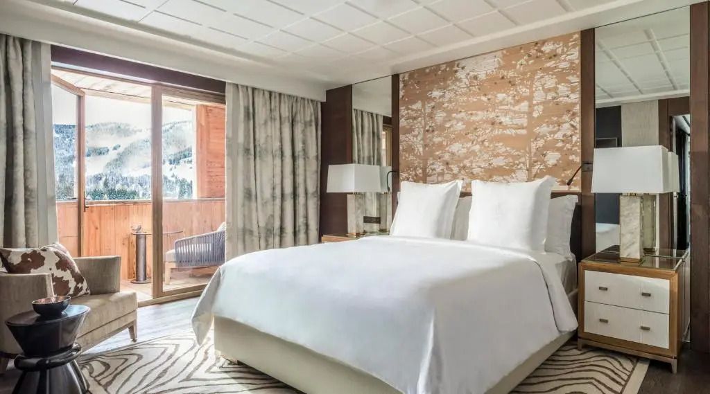 Helles Deluxe Doppelzimmer mit großem Bett und Balkon im Four Seasons Hotel Megeve.