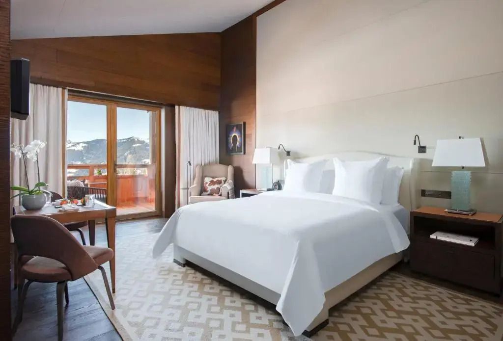 Luxuriöses Doppelzimmer mit großem Bett und Balkon mit Bergblick
