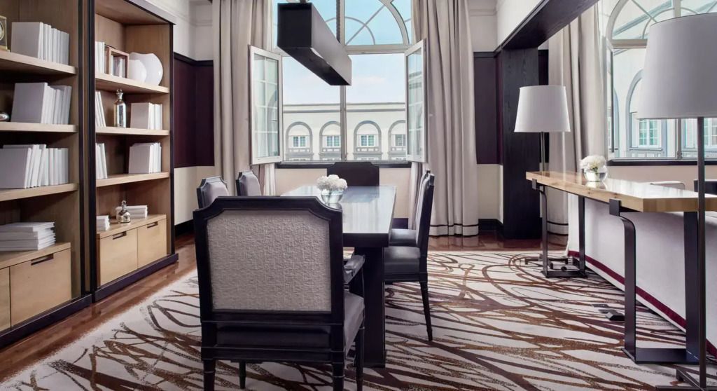 Elegantes Wohnzimmer der Ambassador Suite mit modernem Esstisch und großen Fenstern
