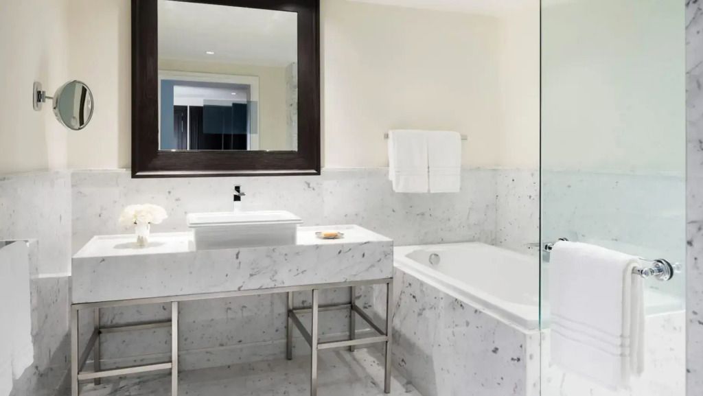 Luxuriöses Badezimmer in der Suite mit Marmorverkleidung und geräumiger Wanne