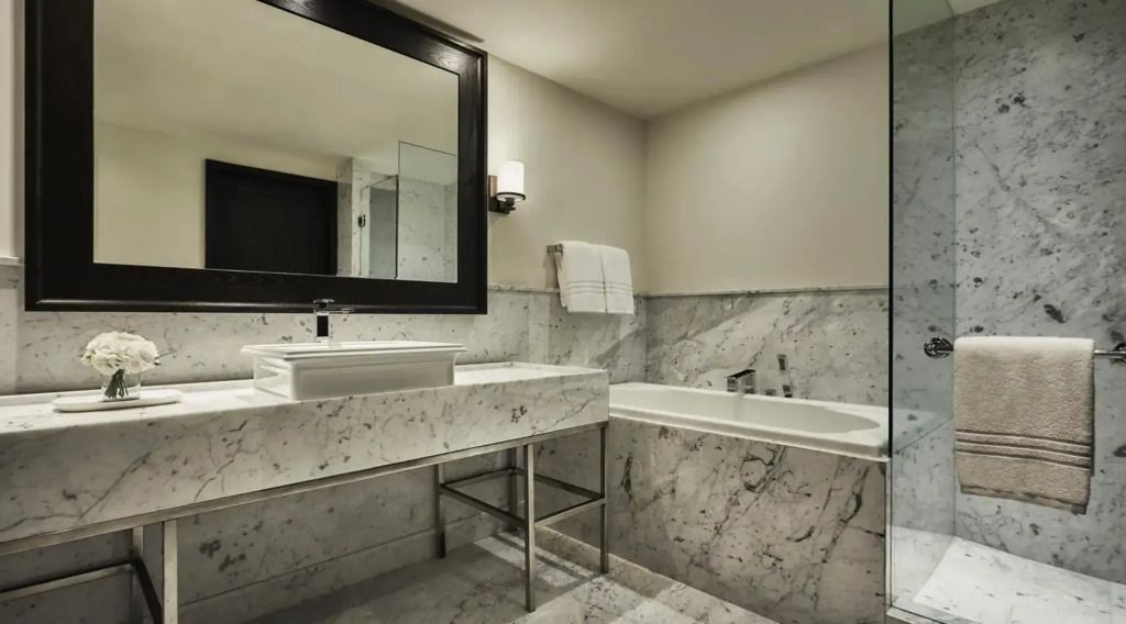 Geräumiges Badezimmer mit Marmorwaschbecken und großer Badewanne.