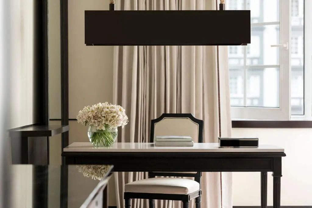 Einladender Schreibtisch mit Blumen und stilvollem Stuhl.