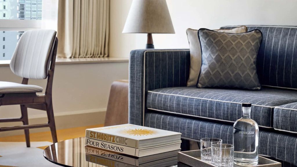Detailaufnahme einer eleganten Couch mit stilvollen Kissen und Designbüchern