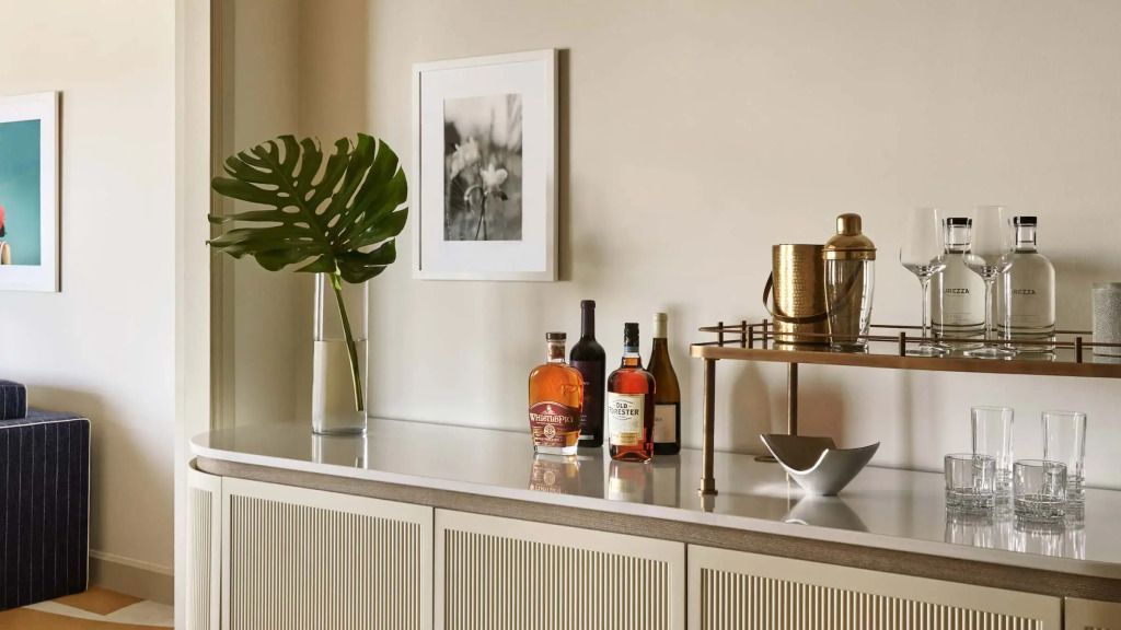 Bartheke mit erlesenen Spirituosen und elegantem Kunstwerk im Hintergrund
