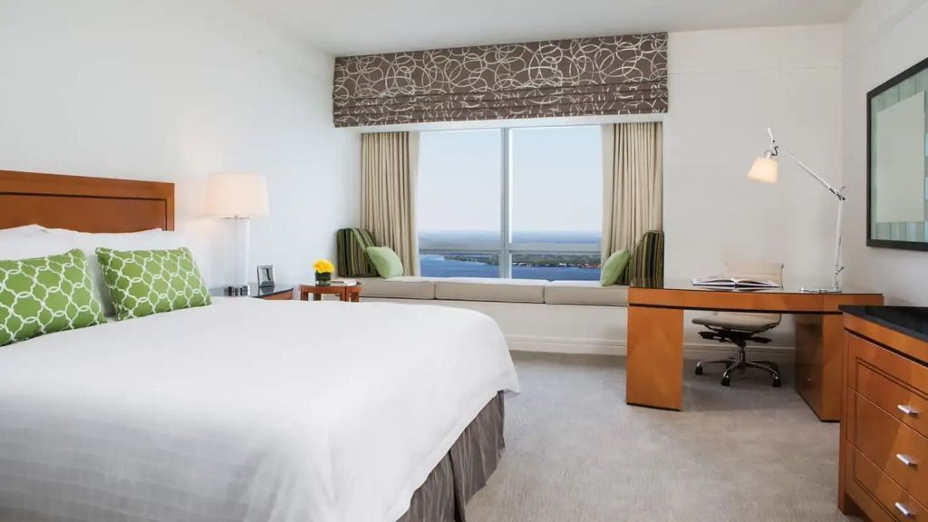 Elegantes Schlafzimmer mit Doppelbett und Panoramafenster mit Meerblick