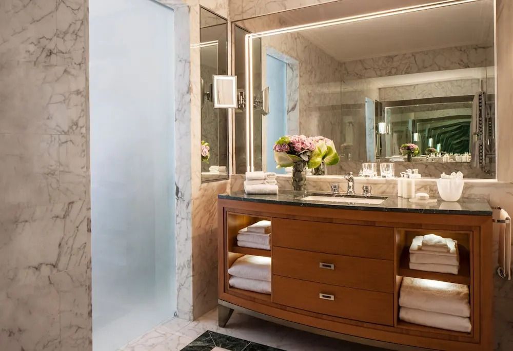 Elegantes Badezimmer mit marmornem Waschtisch und Blumenarrangement